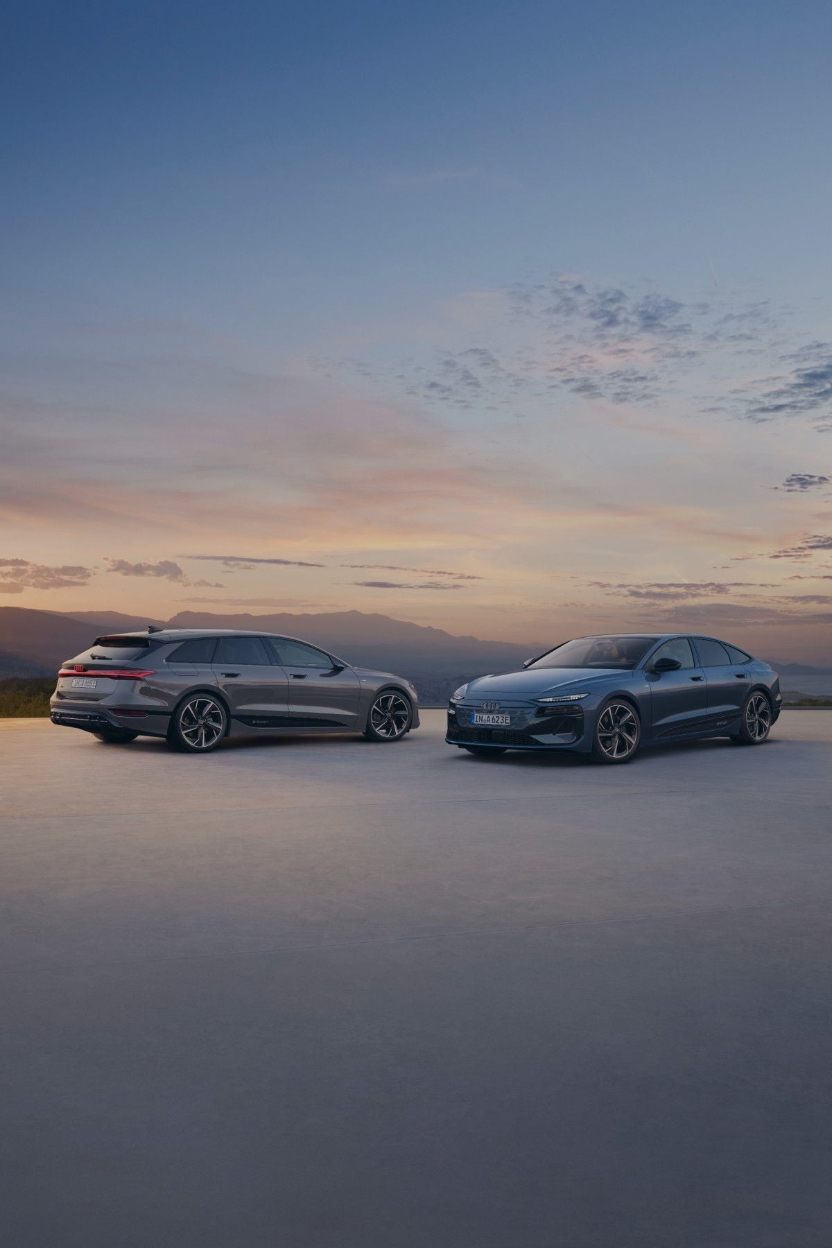 Two Audi cars facing each other side by side with beautiful sky at the back